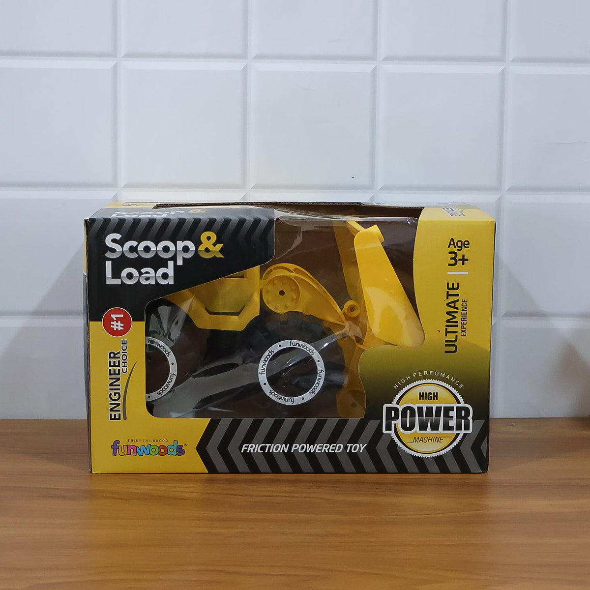 Close-up of friction wheels on yellow plastic toy front-end loader