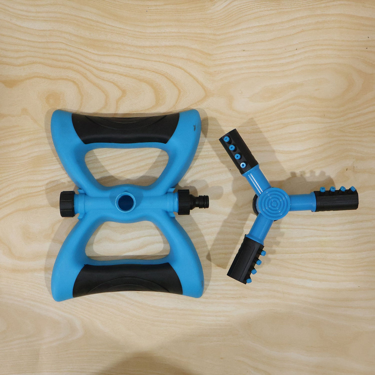 Blue and black rotating lawn sprinkler in daily garden use