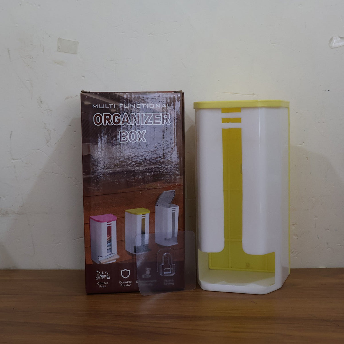 A white and yellow plastic bag dispenser sits next to its