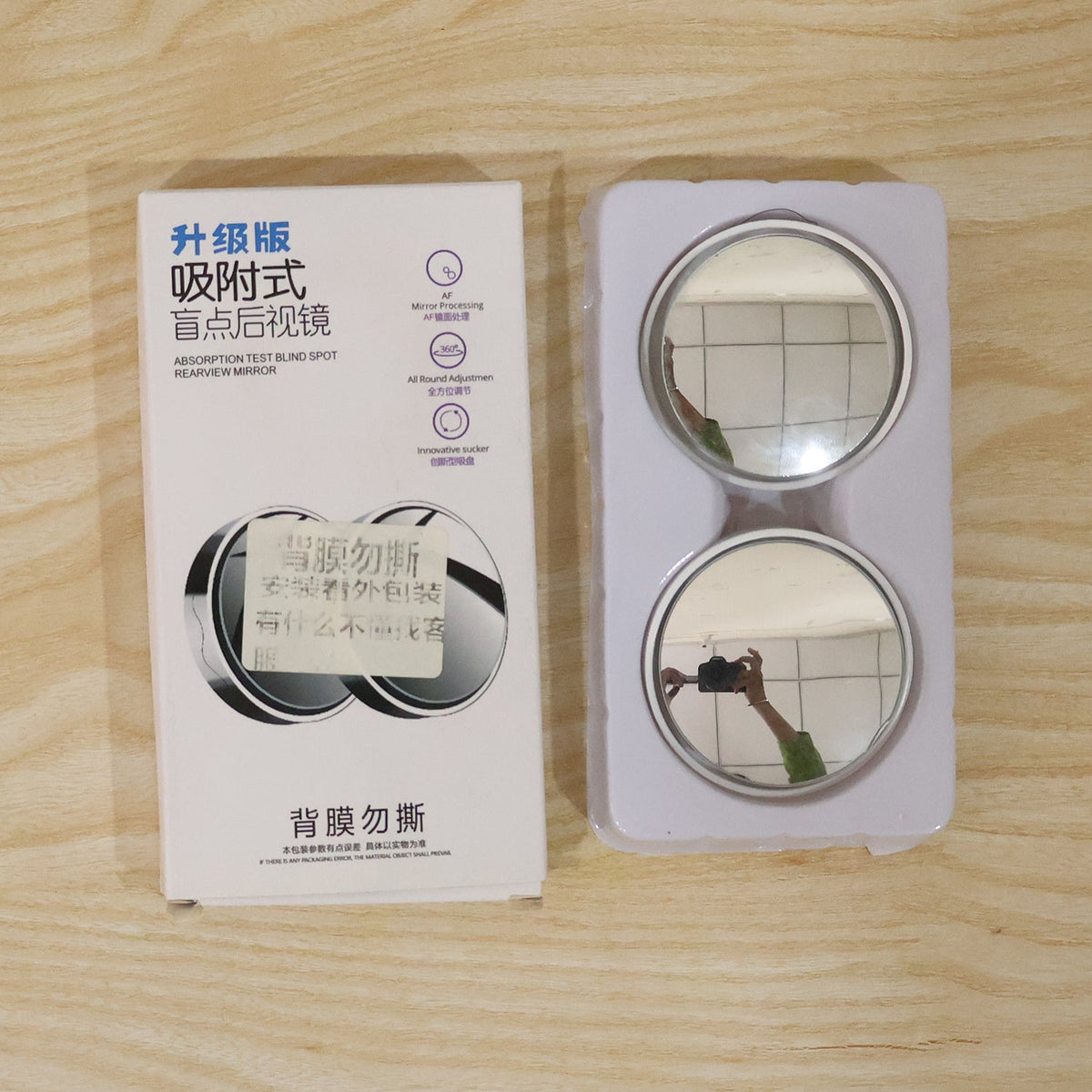 A white box with Chinese text next to two round mirrors in clear plastic packaging.