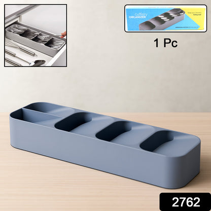 A gray plastic cutlery organizer sits on a wooden surface, with an inset image showing it in a drawer and its packaging.