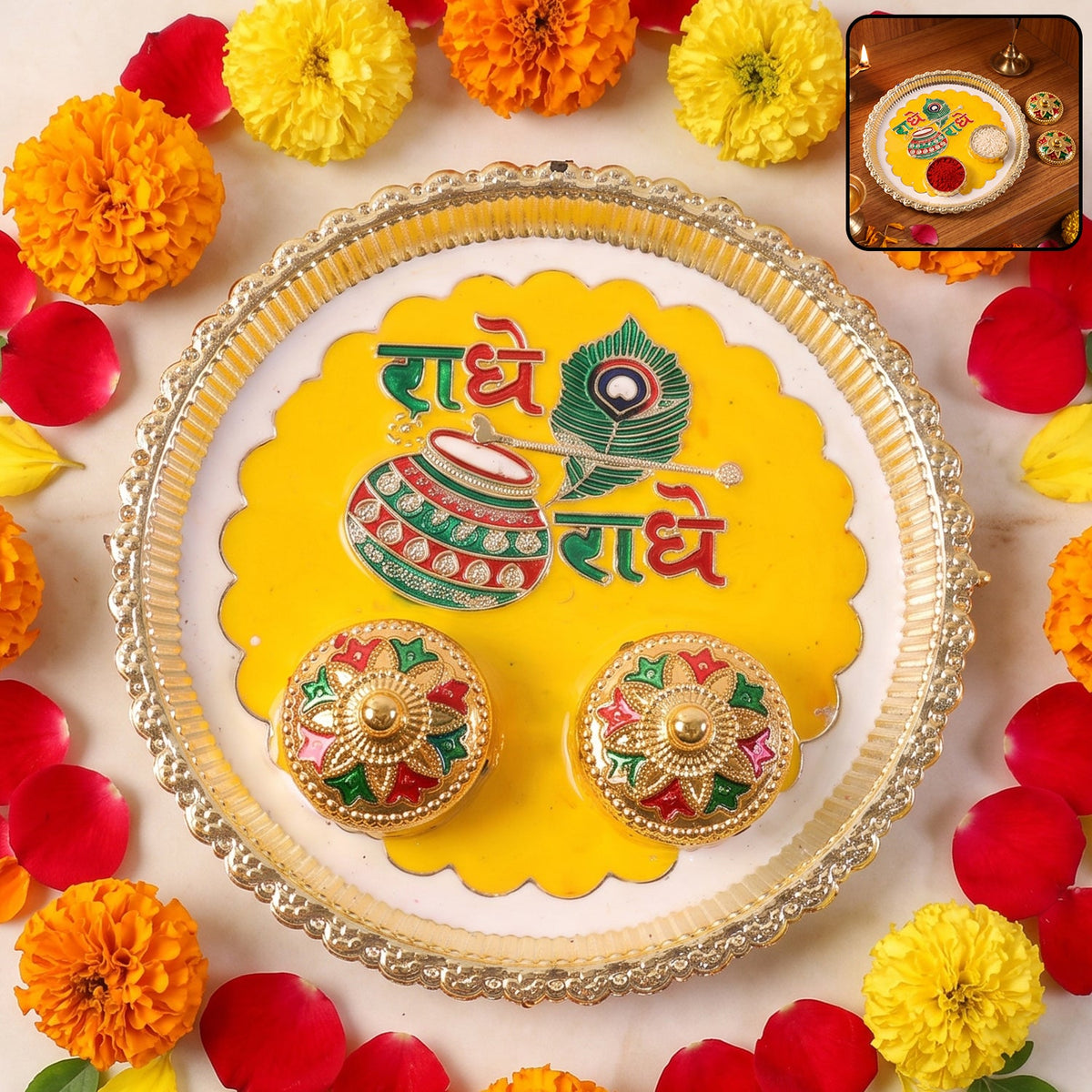 A silver and yellow Radhe Radhe pooja thali set with two small decorative containers, surrounded by marigolds and rose.
