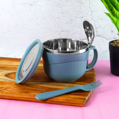 A blue insulated bowl with a lid, a spoon, and a fork on a wooden board against a pink and white background.