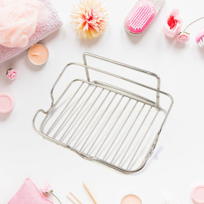 A stainless steel wire soap dish is shown from above, surrounded by pink towels and bath products.