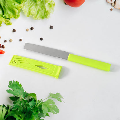 A green handled knife with a silver blade and a matching green sheath, surrounded by herbs and vegetables.