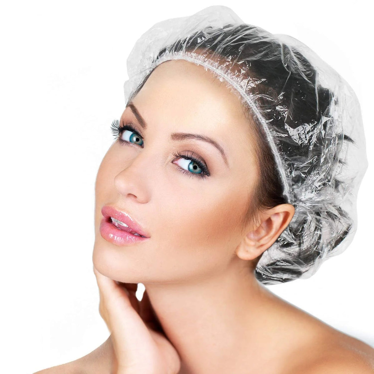 A woman with blue eyes wearing a clear shower cap, looking over her shoulder.