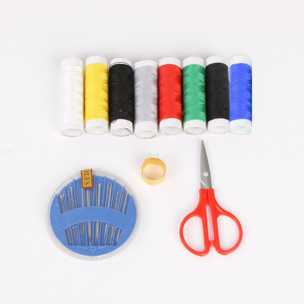 A collection of sewing essentials, including colorful thread spools, a needle case, thimble, and scissors.