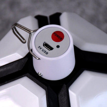 Close-up of the white top of the lantern showing a red power button, a 5V USB port, and a metal hook.
