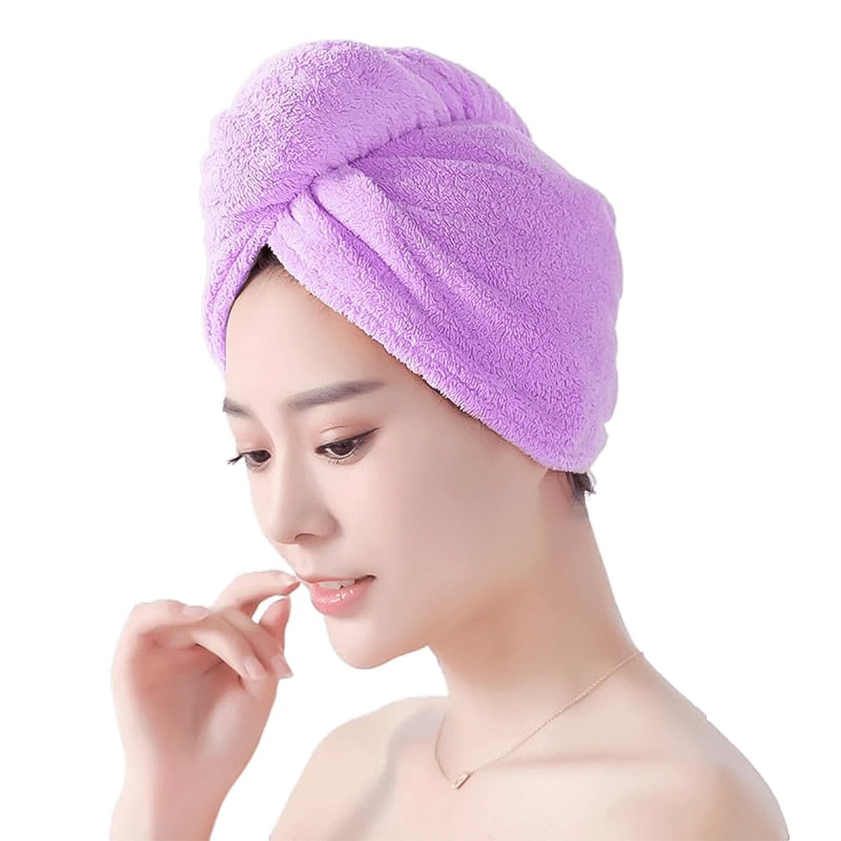 A woman with a purple microfiber hair wrap on her head smiles gently, touching her chin with one finger.