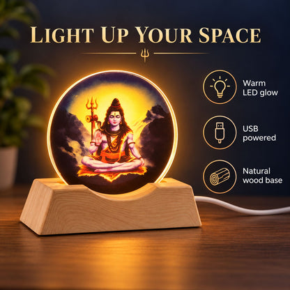 Illuminated circular acrylic panel with Lord Shiva in meditation, set on a natural wood base with a warm glow.