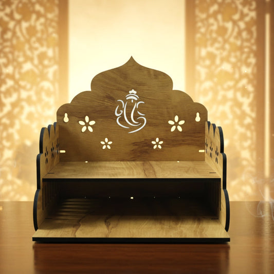 A light brown wooden pooja stand with a Ganesha symbol and flower cutouts, emitting smoke from the right.