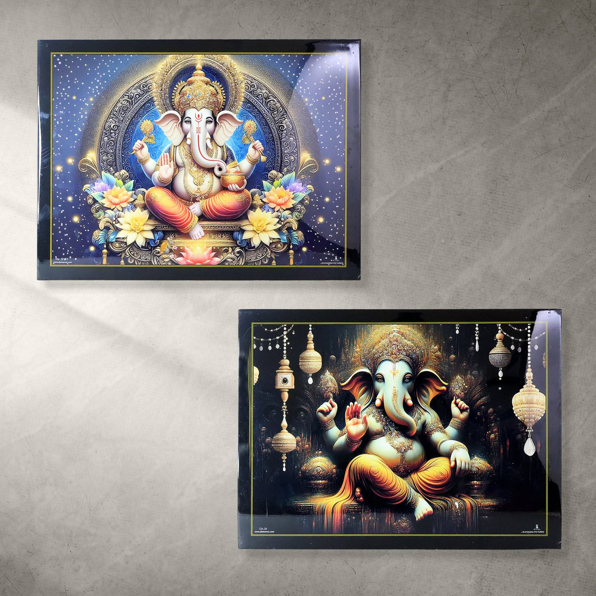 Two framed Lord Ganesha paintings, one with a starry blue background and another with dark, ornate hanging lanterns.