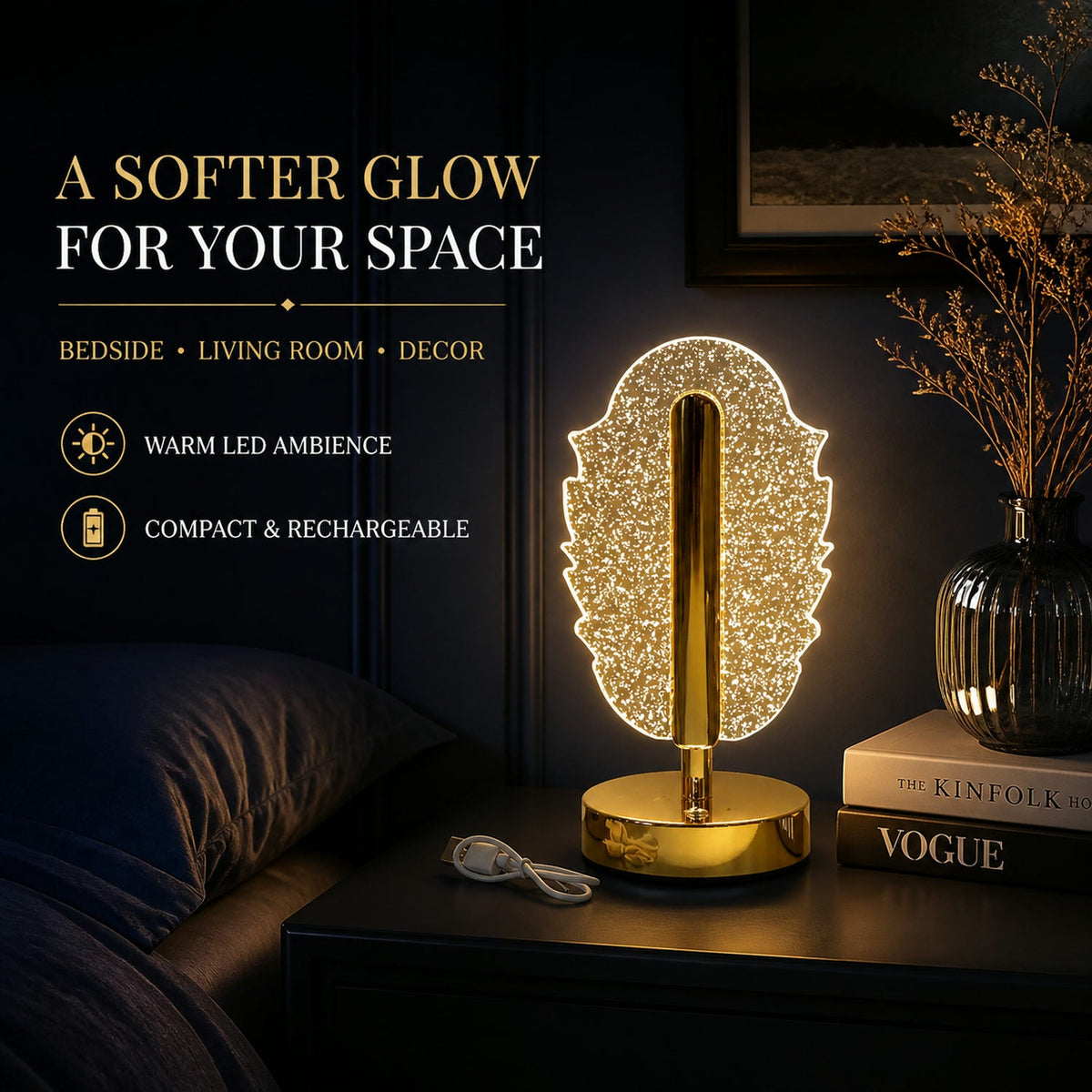 A glowing feather-shaped crystal table lamp on a bedside table with books, a vase, and a USB cable.