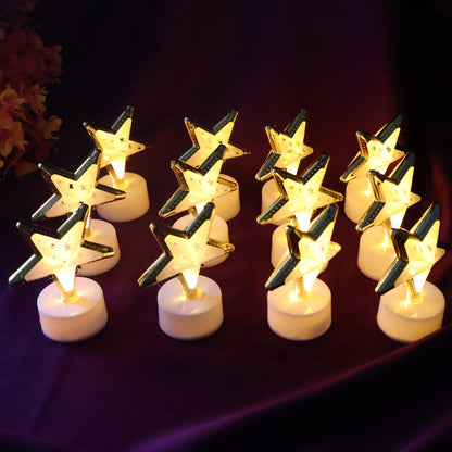 Twelve glowing star-shaped LED candles with gold frames and white bases arranged on a dark purple fabric.
