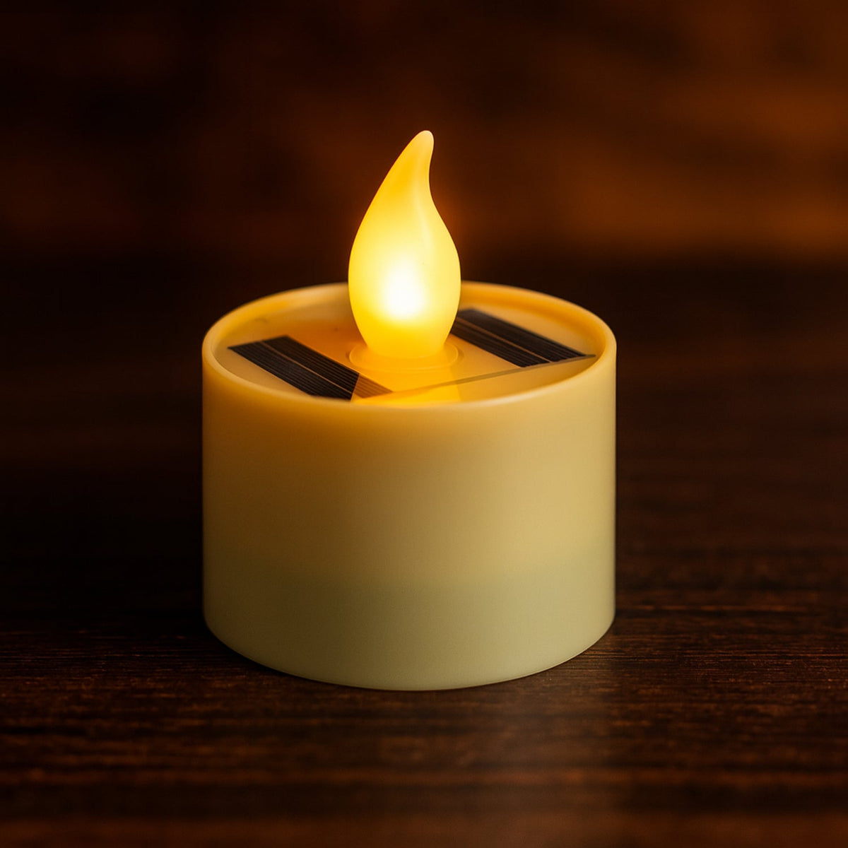 A single solar-powered LED candle lamp with a warm yellow glow sits on a dark wooden surface.