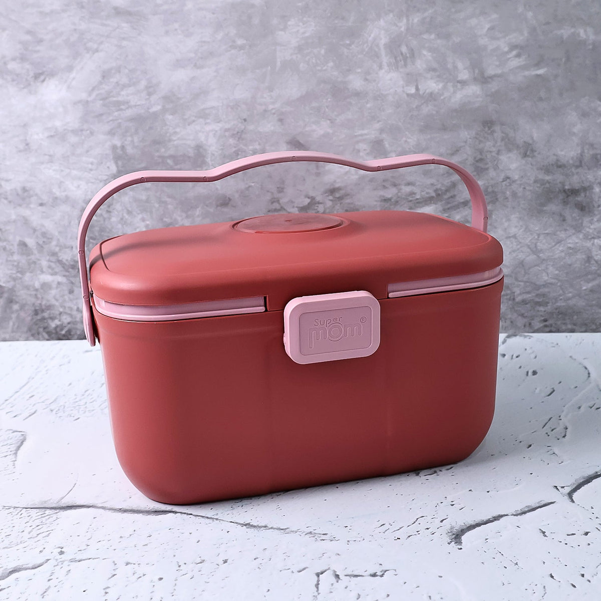 Closed red and pink plastic storage box with a wavy pink handle and a 'Super Mom' clasp, on a grey surface.