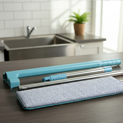 The disassembled blue and silver flat mop components and grey microfiber pad laid out on a dark countertop.