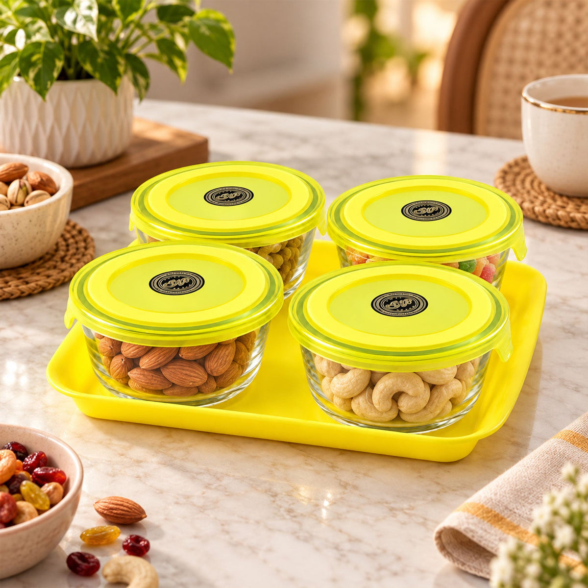 Four glass bowls with yellow lids on a tray, filled with various nuts and dried fruit.