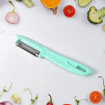 A teal vegetable peeler with a serrated edge and a stainless steel blade, surrounded by various vegetables.