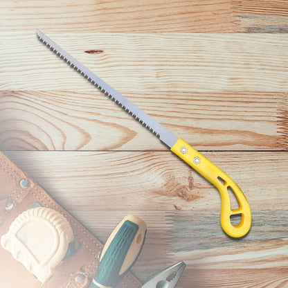 A yellow-handled pruning saw is displayed on a light wooden surface with blurred tools in the foreground.