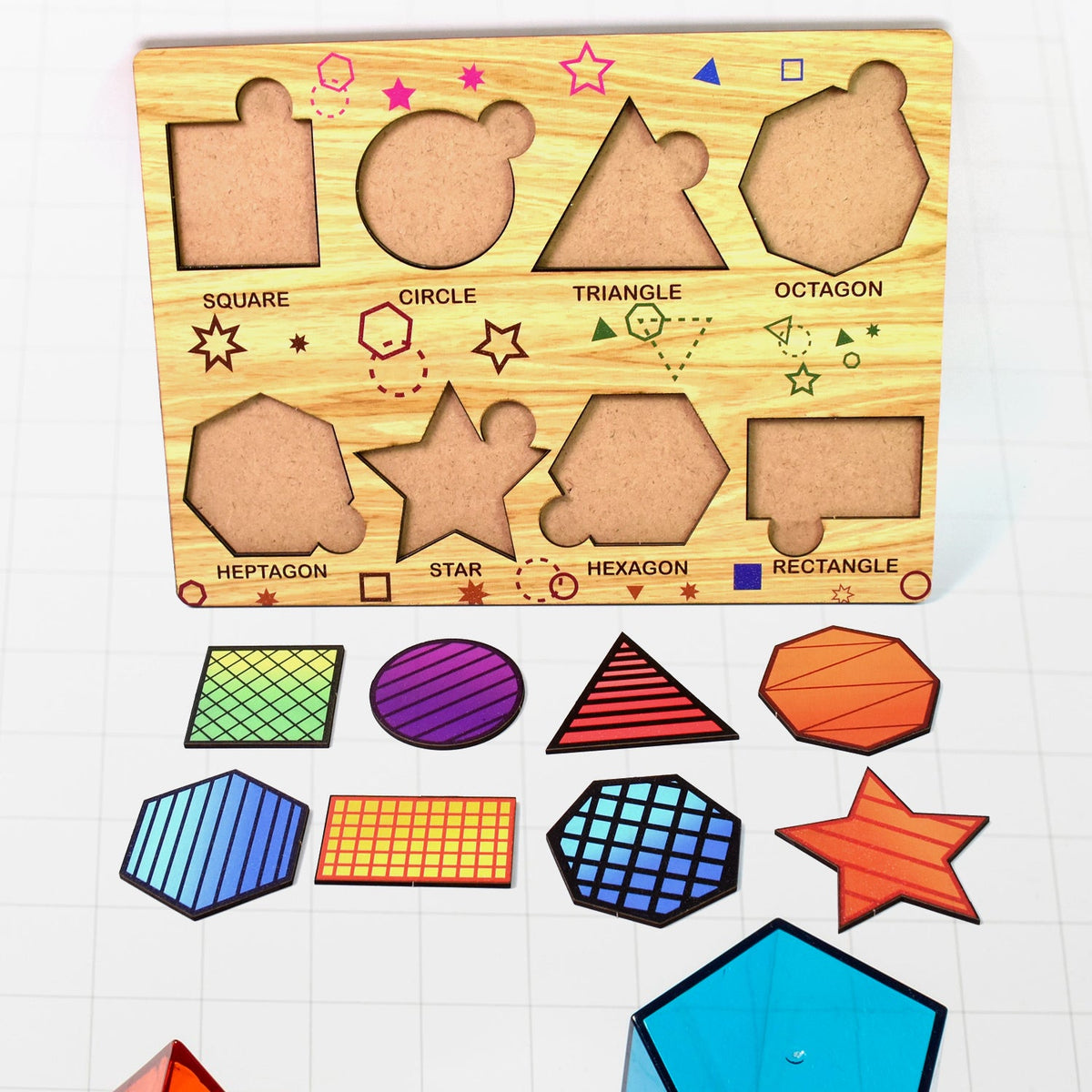 The wooden shape sorting puzzle board is empty, with all colorful geometric pieces laid out below it.