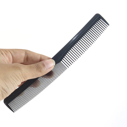 A hand holds a black dual-tooth comb against a plain white background.