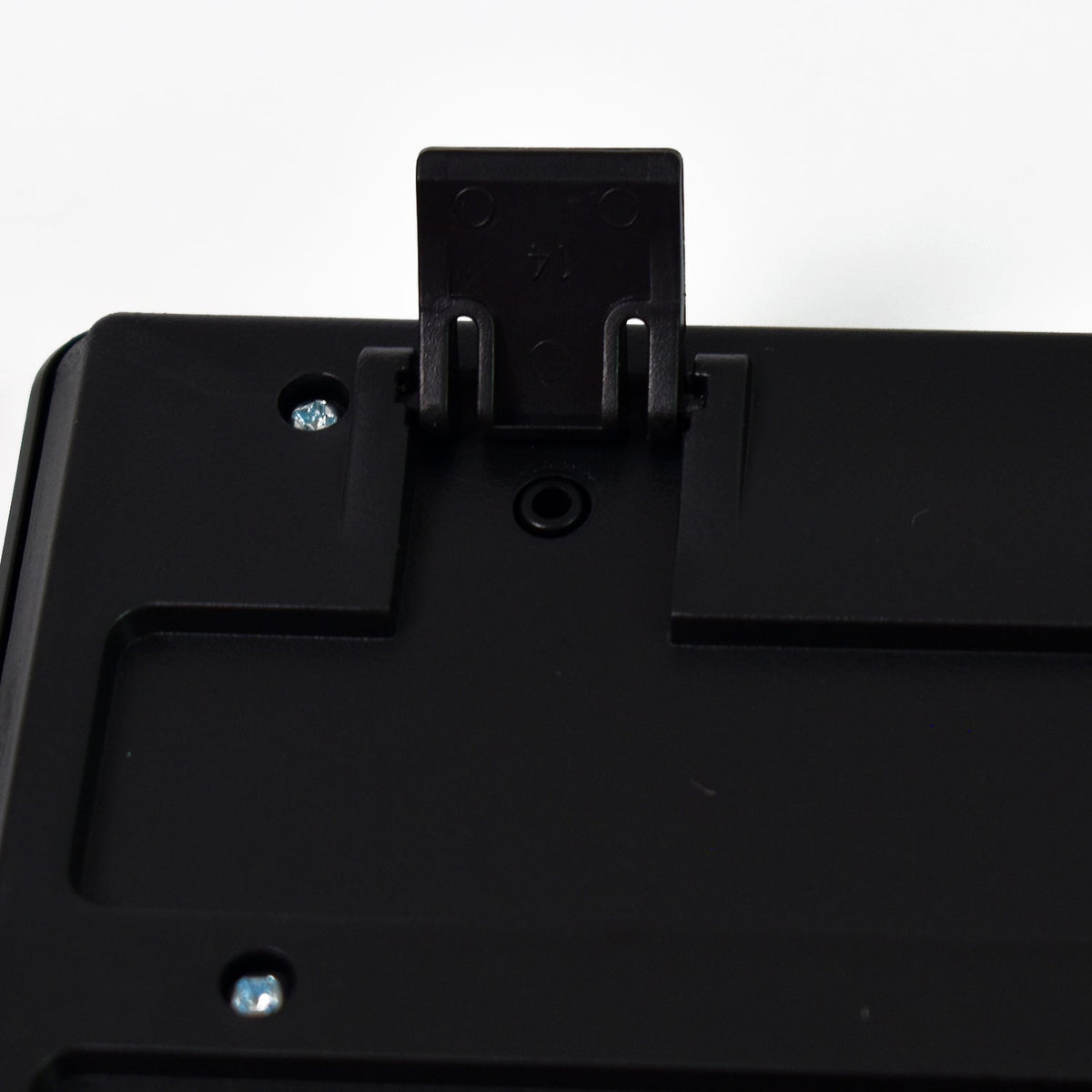 A close-up of the back of a black keyboard showing an extended kickstand and screws.
