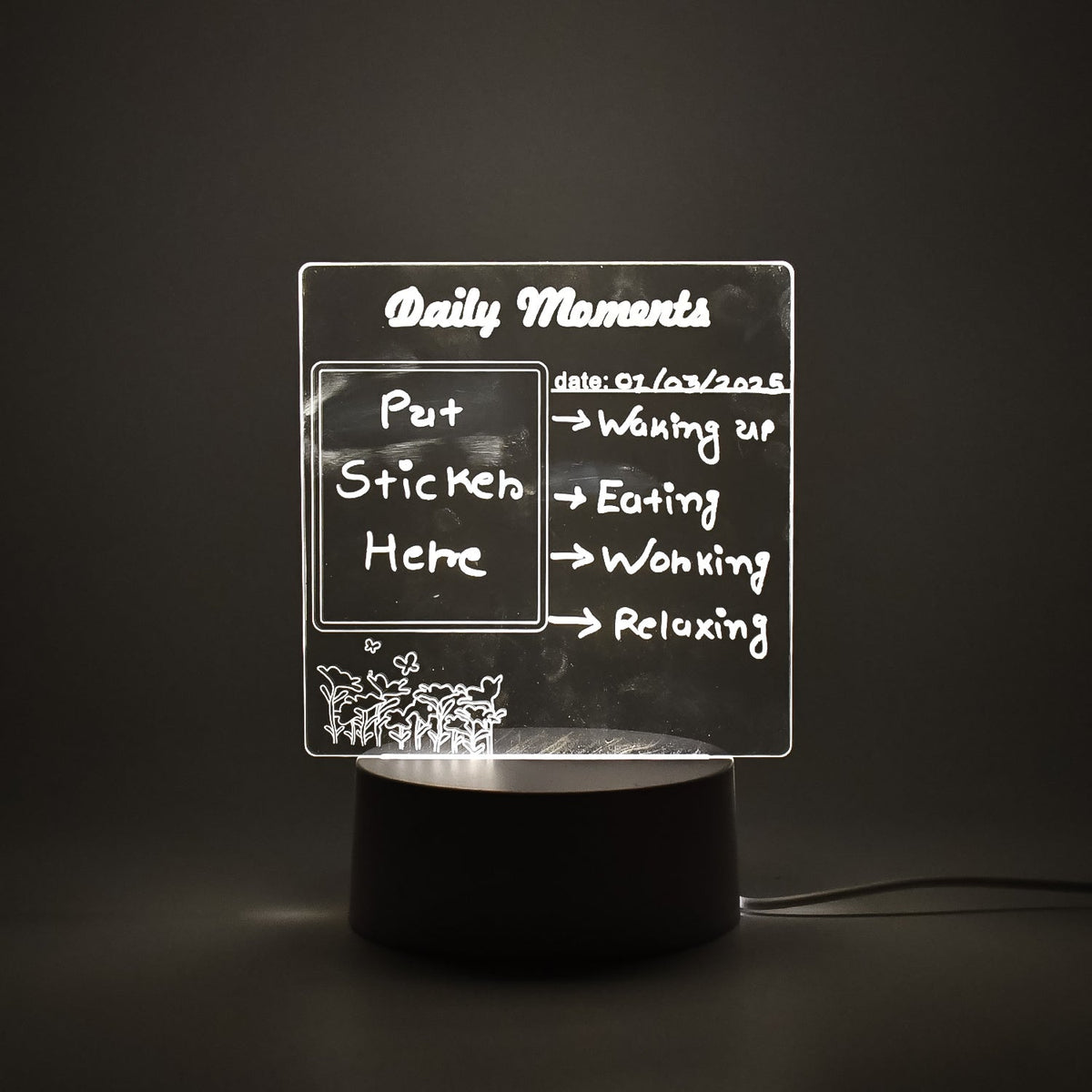 A clear acrylic message board lamp with glowing white text, set against a dark background.