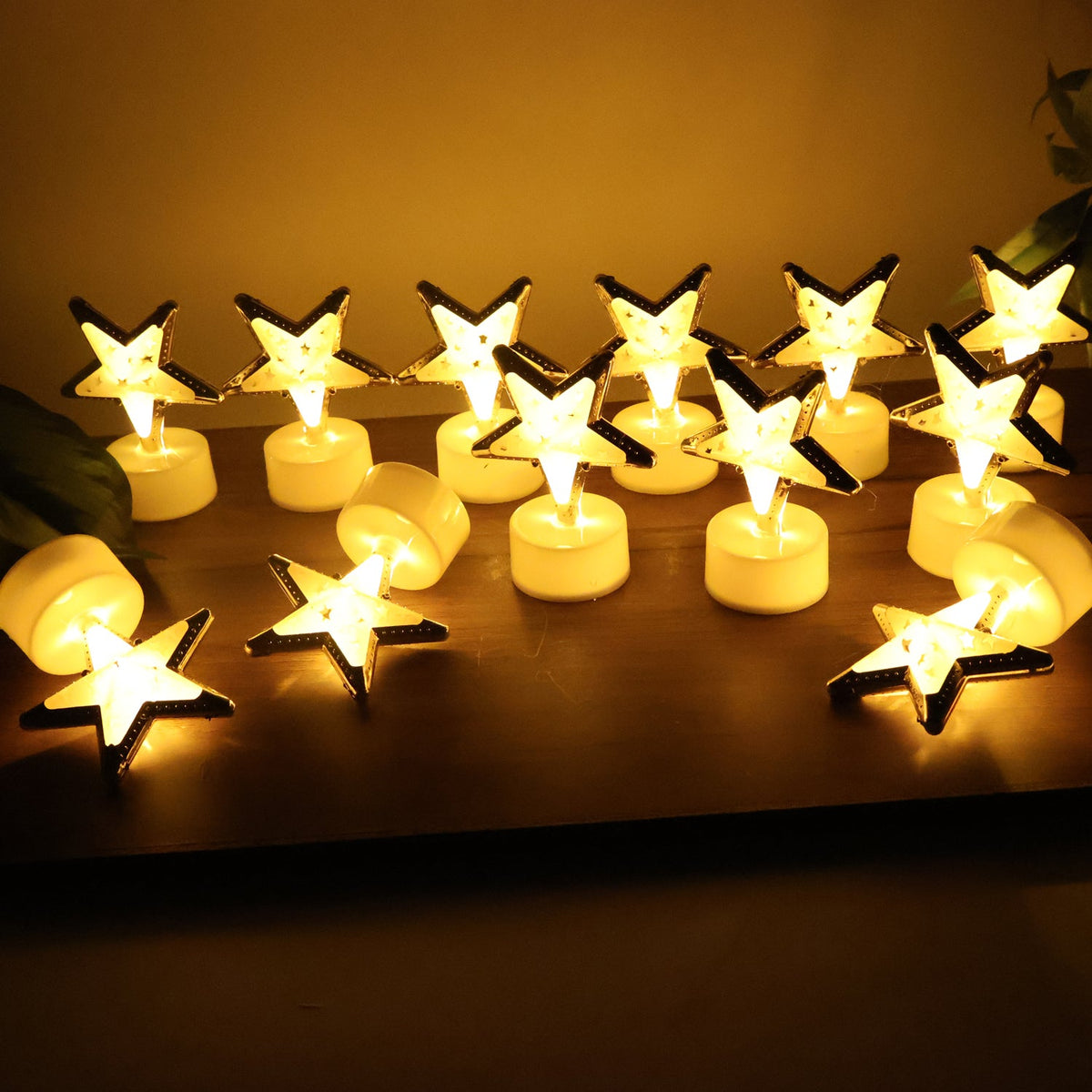 Thirteen glowing star-shaped LED candles, some upright and some on their sides, scattered on a dark wooden surface.