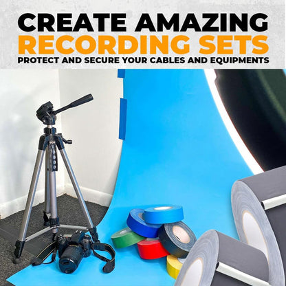 A camera on a tripod in a studio setting with various colored tape rolls on a blue backdrop.