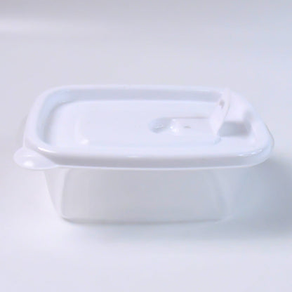 Side view of a single clear plastic food container with a white lid on a plain white background.