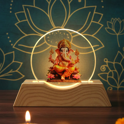 Lord Ganesha LED lamp with a golden glow against a dark blue background with lotus patterns.