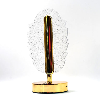 A feather-shaped crystal table lamp with a gold base on a white background, viewed from a slight angle.