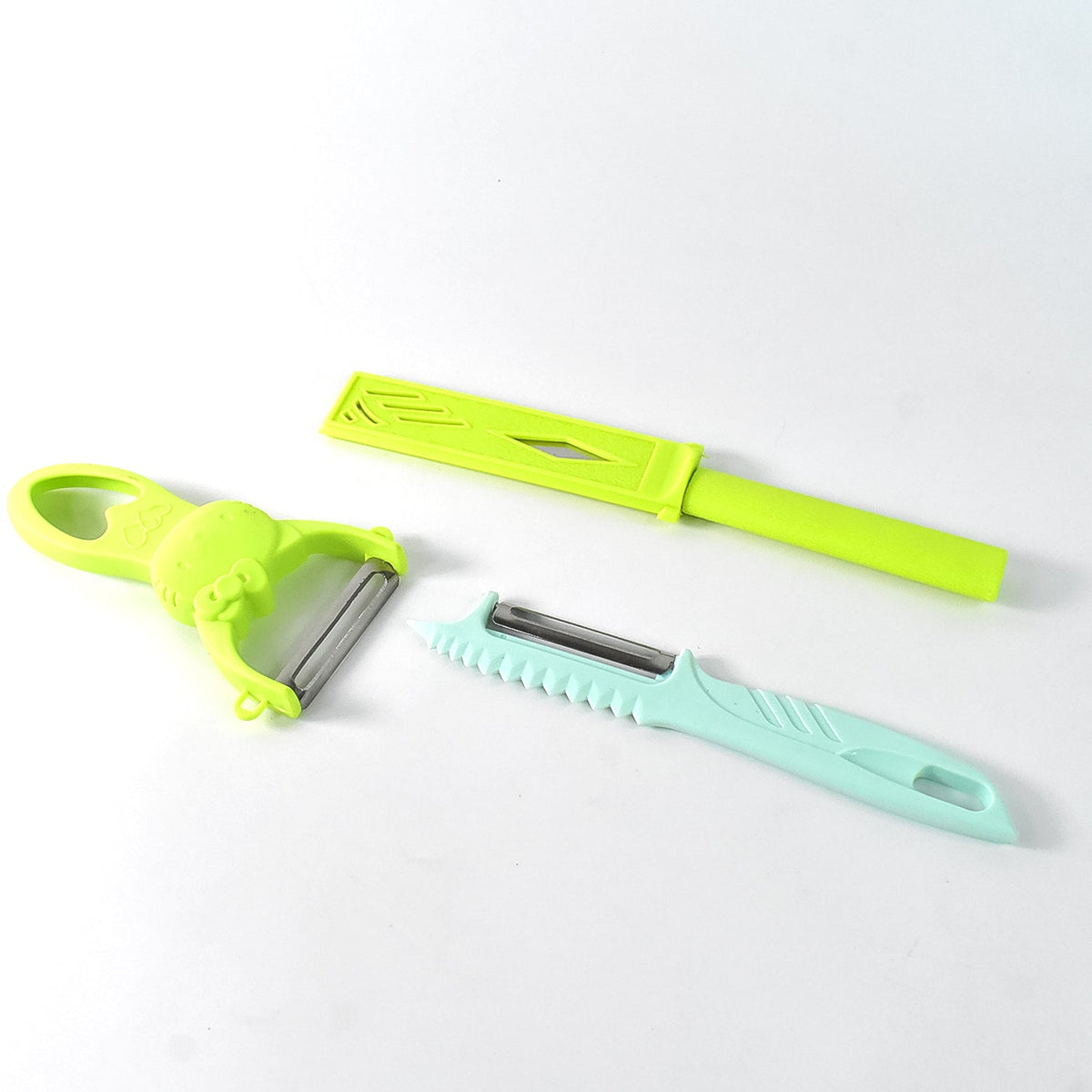 Three kitchen tools: a green peeler, a teal peeler, and a green knife with its sheath, on a white background.