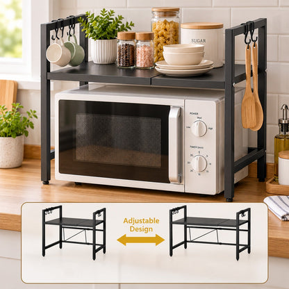 Black metal microwave oven rack with a white microwave, mugs, and spices on a wooden counter.