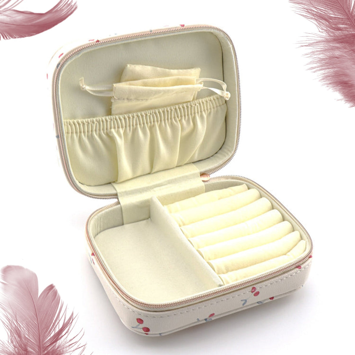 An open cherry print jewelry organizer case with empty compartments and a small pouch, surrounded by feathers.