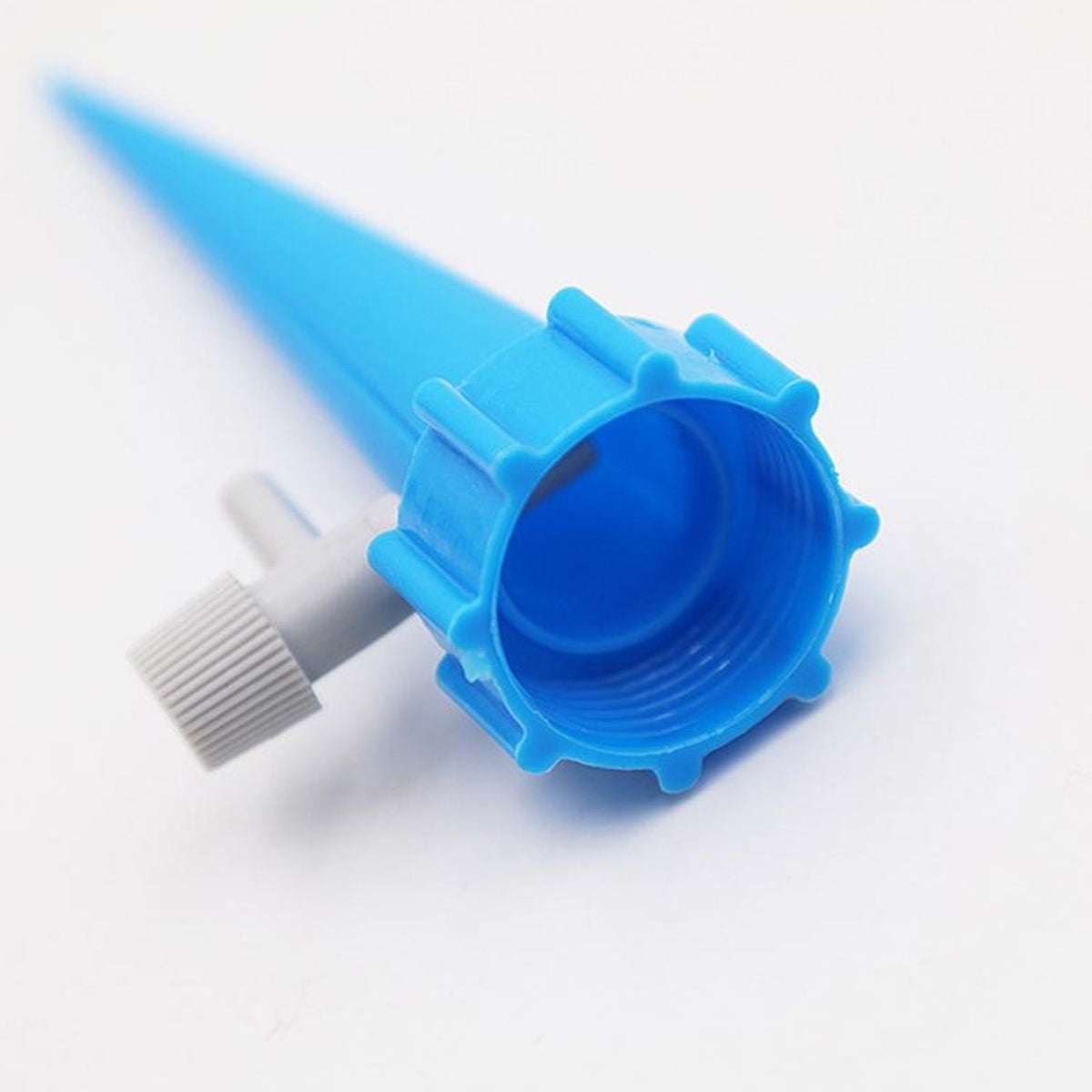 A close-up of the top of a blue watering spike with a gray regulating valve on a white background.