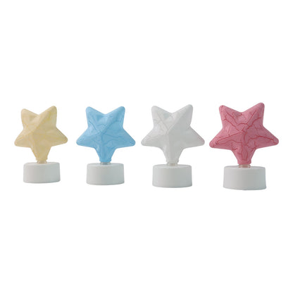 Four unlit star-shaped LED tealight candles in yellow, blue, white, and pink, arranged in a row on a white background.