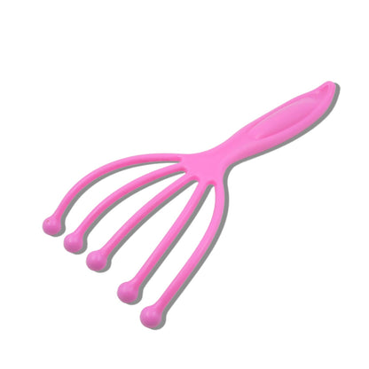 A bright pink plastic scalp massager with five flexible arms, each ending in a rounded pink tip, casting a shadow on a white