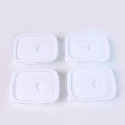 Top-down view of four clear plastic food containers with white lids neatly arranged on a plain white background.