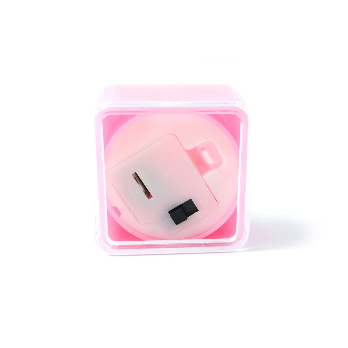 The underside of a pink square LED flameless tealight candle, showing the battery compartment and switch.
