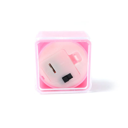 The underside of a pink square LED flameless tealight candle, showing the battery compartment and switch.