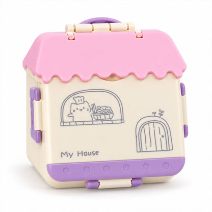 A closed house-shaped lunch box with a pink roof, cream walls, and purple base, featuring a cartoon cat design.