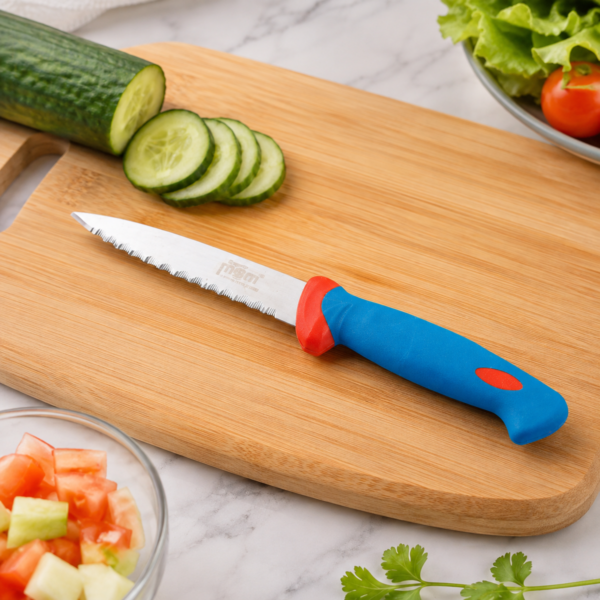 A blue and red handled serrated paring knife rests on a wooden cutting board with sliced cucumber. A bowl of chopped salad