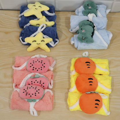 Four stacks of colorful towels with attached plush shapes, arranged on a light wooden surface.