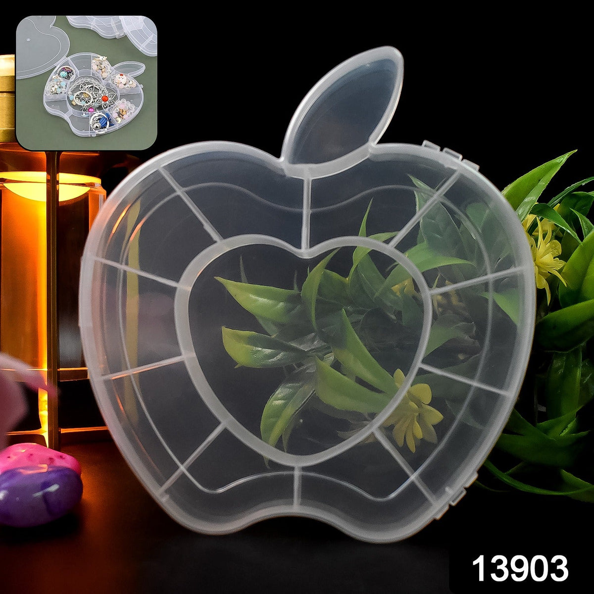 A transparent apple-shaped organizer box with a heart-shaped center compartment, containing green foliage, is displayed