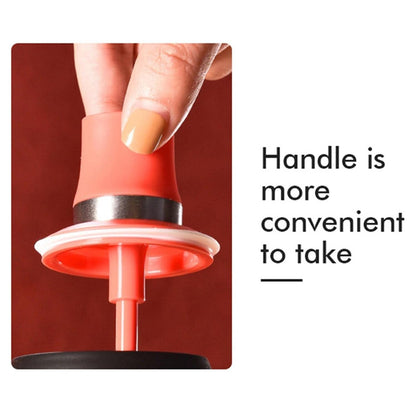 A close-up of a hand holding the red top of the oil dispenser, with text about convenient handle.