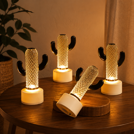 Four glowing cactus-shaped LED lights with gold mesh bodies and black arms sit on a wooden table.
