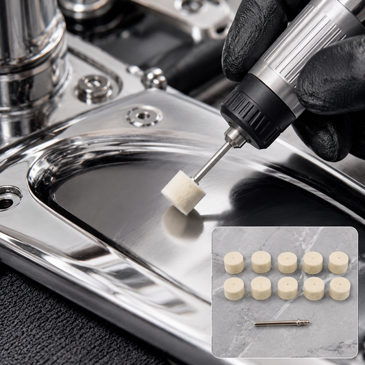 A hand in a black glove uses a rotary tool with a small white felt polishing pad on a shiny metal surface, with a pack of 10