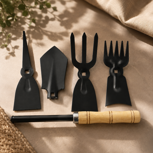 Four black metal gardening tool heads and one wooden handle with a black shaft, arranged on a beige surface.